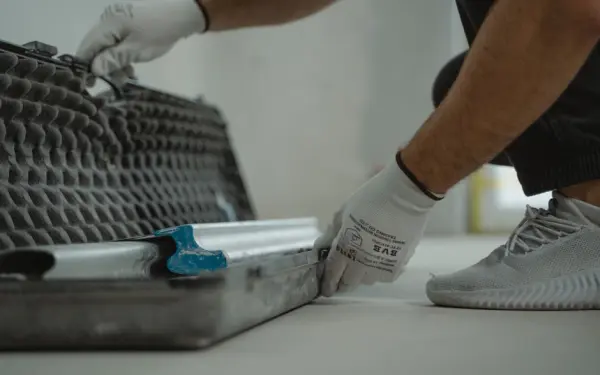 A construction worker organizing tools inside a toolbox on a job site.