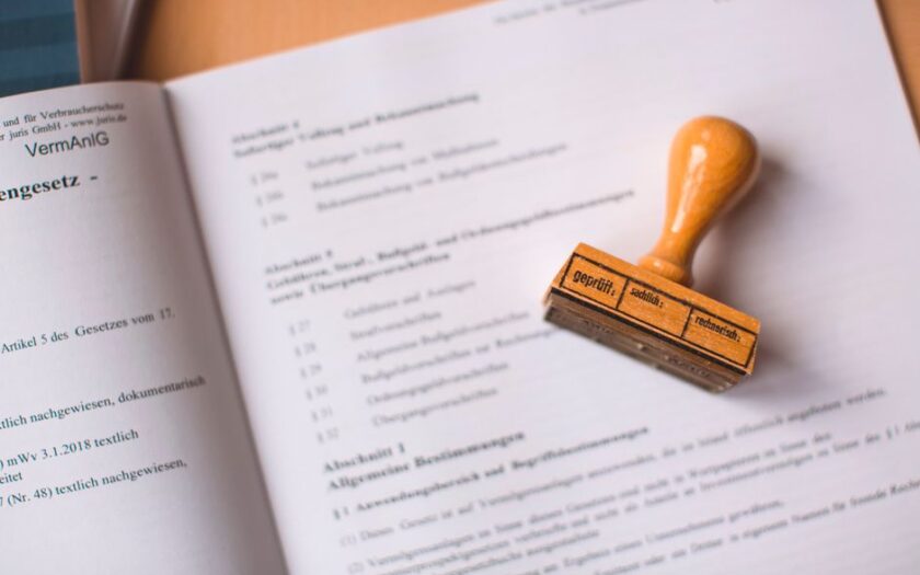 Close-up of a legal document with a wooden stamp placed on top, highlighting verification.