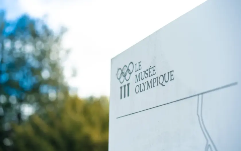 a close up of a sign with trees in the background