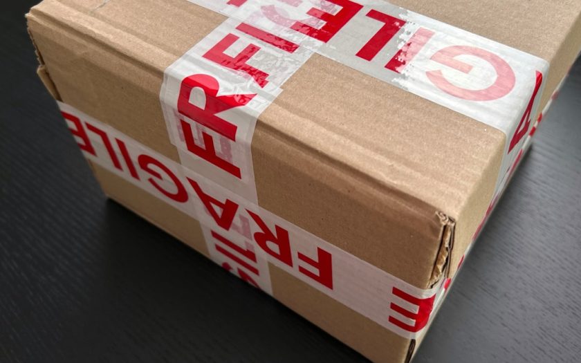 Cardboard box sealed with red fragile tape