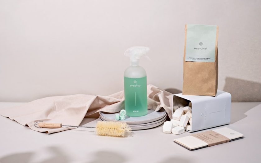 a white table with a bottle of soap, a brush, and other items
